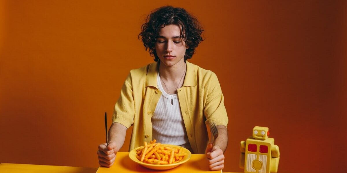 man with plate of chips looking bored