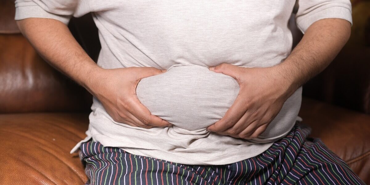 man showing his fat on stomach