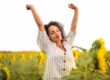 woman in sunflower field looking energetic