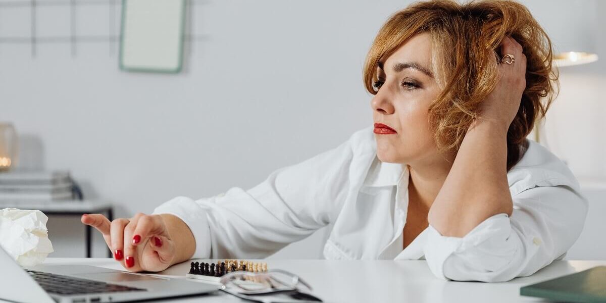 woman at desk looking stressed