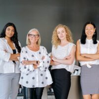 group of smiling woman with arms crossed