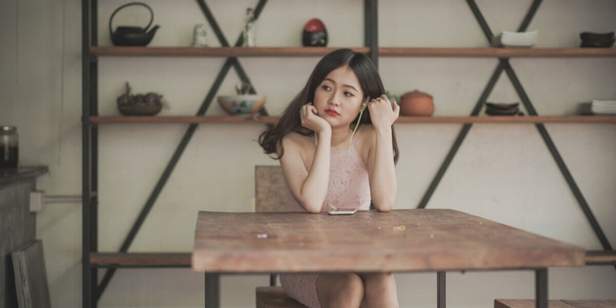 woman sitting behind desk looking contemplative