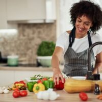woman slicing vegetables in kitchen