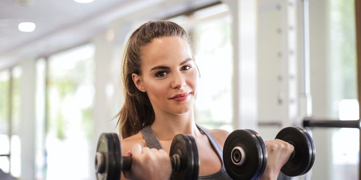 young woman with weights 1200×800 young woman doing bicep curl with weights